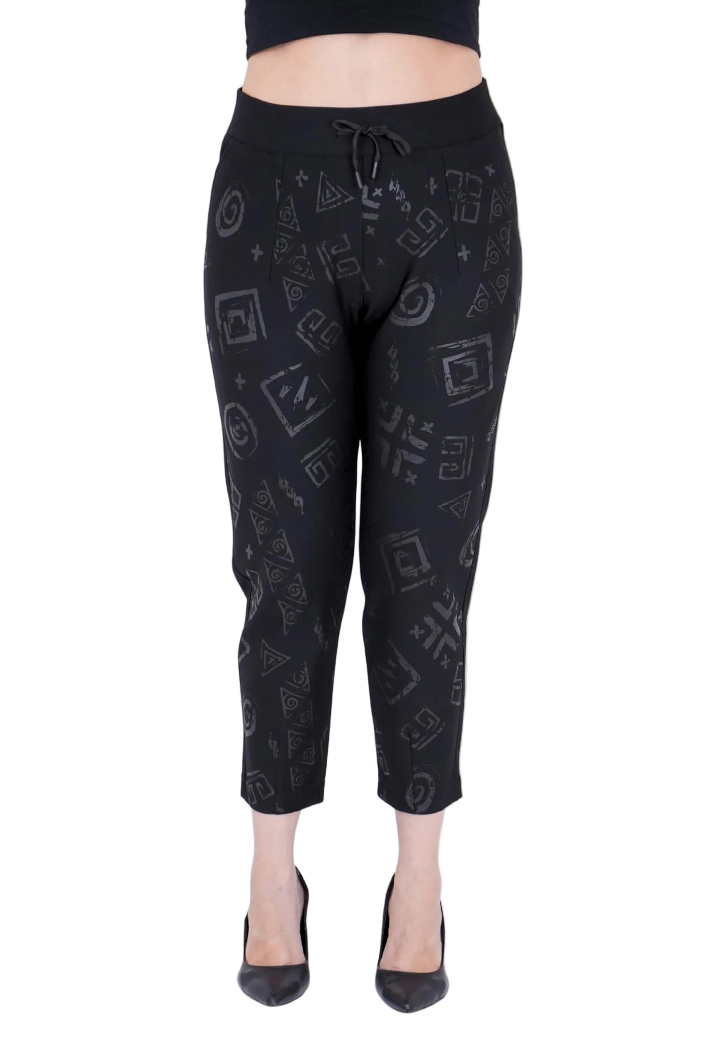 Black capri pants with geometric pattern worn by a person on a white background.