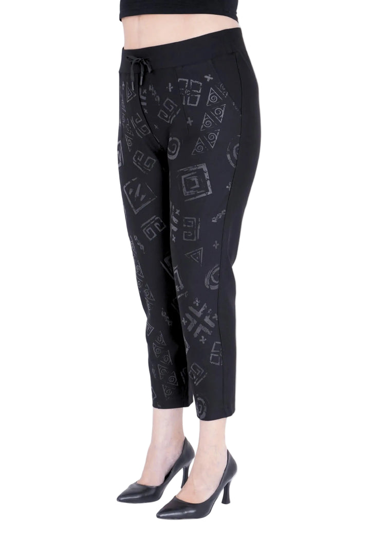 Black jogger pants with geometric pattern worn by a model on a white background, 